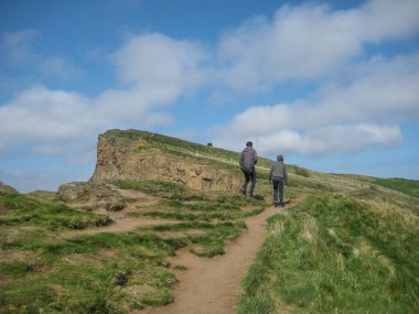 Edinburgh / İskoçya / Uk - 04/20/2014: Holyrood parkın görünümü Salisbury crags yeşil alanlar, yürüyüş ve seyir, arka plan üzerinde mavi gökyüzü Edinburgh turist ile