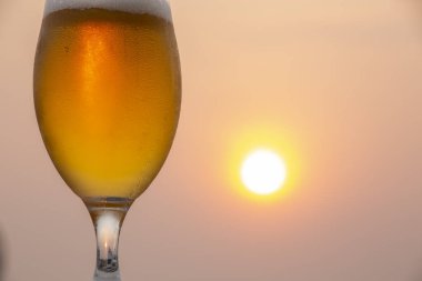 Gün batımı ile bulanık arka plan ayaz ve detaylı bira cam