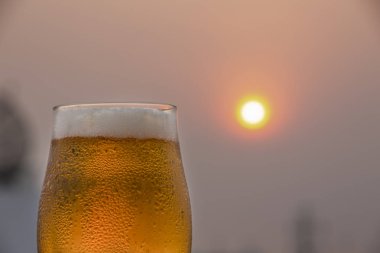 Gün batımı ile bulanık arka plan ayaz ve detaylı bira cam