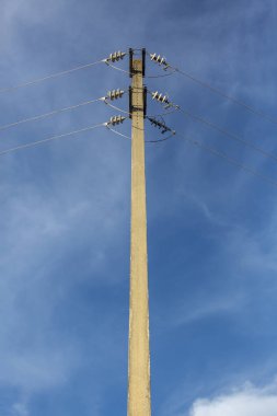 Arka plan olarak elektrik kabloları, mavi gökyüzü ile bir elektrik yazının ayrıntılı görünüm