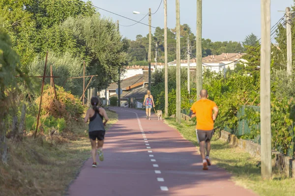 Pedestrian and cycle eco path, woman with a dog and people walking, background and vegetation, in Viseu, Portugal