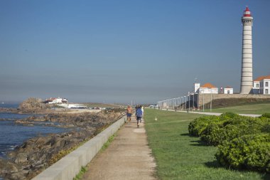 Bir deniz feneri, Ayrıntılar ve çok hassas çerçeveleme ve yürüme, arka plan, Portekiz olarak mavi gökyüzü insanlar ile tipik Portekizce mimarisi ile merkezi marjinal Avenue Geral görünümü