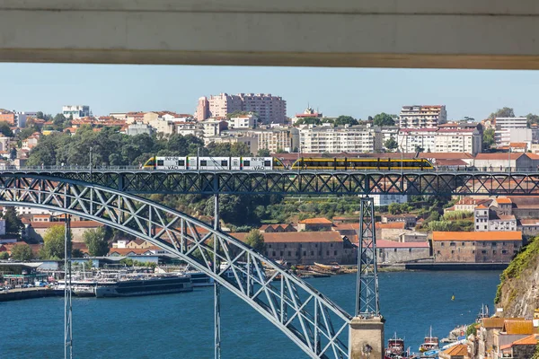 Veduta del ponte D. Luis, con due metropolitane da attraversare in cima, il fiume Douro con barche e la città di Vila Nova de Gaia come sfondo — Foto Stock