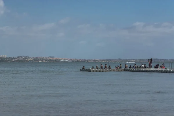 Weergave van kleine dock met mensen over, zee en jet boot, op de kust van Mussulo island, in Luanda, Angola — Stockfoto