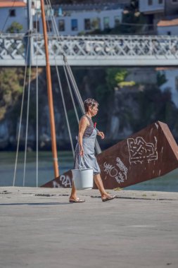 Porto / Portekiz - 10/02/2018: el Beyaz kova ile yürüyen ev hanımı kadın görünümünü