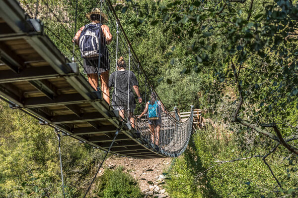 Ароука / Португалия - 10 12 2018: Вид на людей, идущих по подвесному мосту по пешеходной дорожке, с видом на реку Паиву
