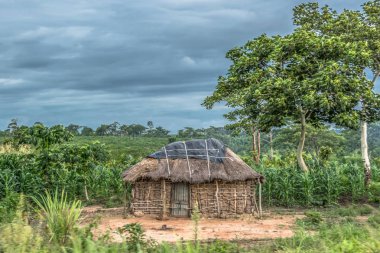 Geleneksel köy, thatched çatı ve pişmiş toprak ve saman duvarlar, evin arka plan olarak bulutlu gökyüzü görünümü