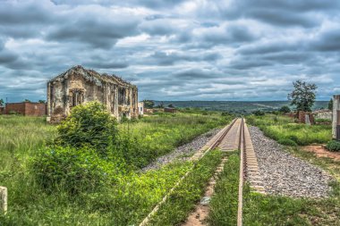 Tren hattı, yıkık ev ve tropikal bitki örtüsü, Angola bulutlu arka plan görünümü