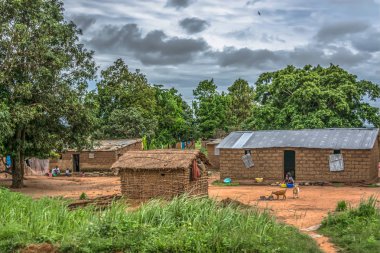 Malange / Angola - 12 08 2018: geleneksel köy, insanların görünümünü ve thatched ve çinko levha çatı evleri ve pişmiş toprak tuğla duvarlar, arka plan, Angola olarak bulutlu gökyüzü