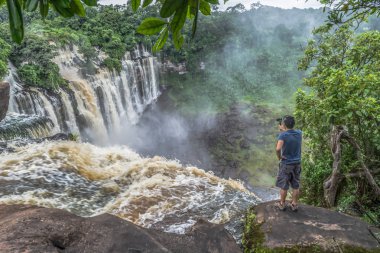 Malange / Angola - 12 08 2018: Kalandula çağlayan bir kaya üzerinde, bir aksiyon kamerası ile filme adam görünümü