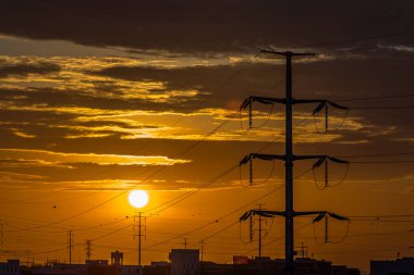 Yüksek gerilim elektrik direkleri görünümünü siluet, arka plan olarak fantastik günbatımı