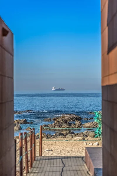 Uitzicht op Atlantische Oceaan, met schip op de horizon, het strand en de ingang naar beachclub op de voorgrond — Stockfoto