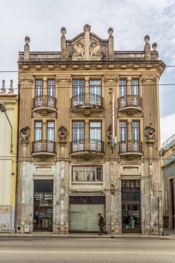 Klasik bir binanın dış cephe görünümü, sokakta yürüyen yaşlı