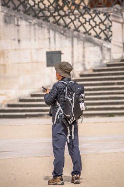 Portekiz 'deki tarihi alandaki anıtlara bakan turistlerin arkası, arka plandaki Coimbra merdivenleri.