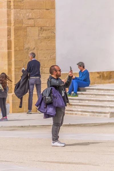 Veduta dell'uomo turistico che scatta foto con il cellulare, in piazza dell'Università di Coimbra, Portogallo — Foto Stock