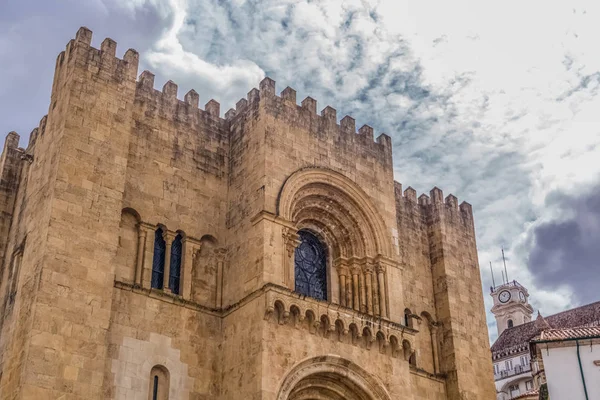 Vista de la fachada frontal del edificio medieval de la Catedral de Coimbra, la ciudad de Coimbra y el cielo como fondo — Foto de Stock