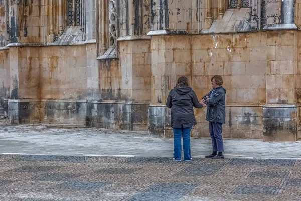 Vista de turistas falando no exterior perto da fachada exterior gótica do Mosteiro da Batalha, Mosteiro da Batalha, literalmente o Mosteiro da Batalha, é um convento dominicano, em Leiria, Por — Fotografia de Stock