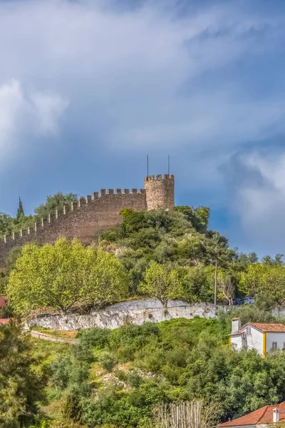 View of the fortress and Luso Roman castle of ��bidos, with buildings of Portuguese vernacular architecture and sky with clouds, in Portugal — стокове фото