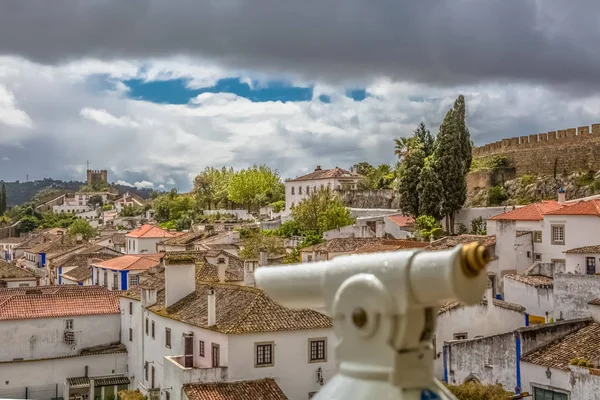 Vista de la fortaleza y el castillo romano de Luso de Obidos, con edificios de arquitectura vernácula portuguesa y cielo con nubes, monóculo borroso en primer plano, en Portugal — Foto de Stock
