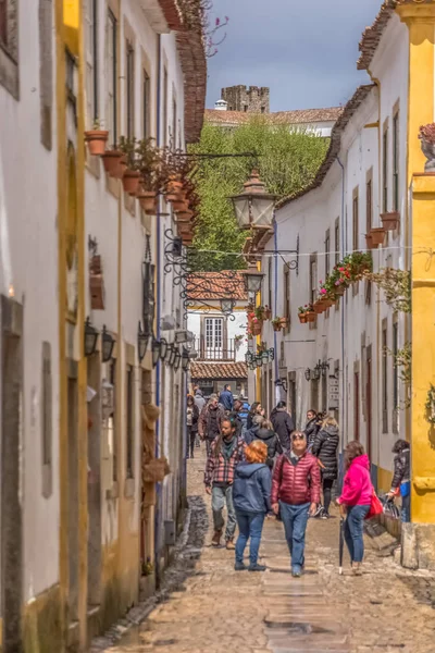 Pohled na portugalskou ulici s budovami a turistickými lidmi, na portugalské středověké vesnici Obidos, v Portugalsku — Stock fotografie