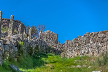 Geleneksel bir şekilde inşa edilmiş granitik taşbinalar ve duvarlar ile tarım alanları ile yaya yolu görünümü
