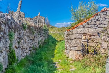 Geleneksel bir şekilde inşa edilmiş granitik taşbinalar ve duvarlar ile tarım alanları ile yaya yolu görünümü