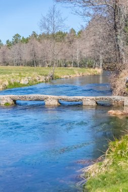 Yaya geçidi için eski ve arkaik taş köprü ile bir nehir manzarası