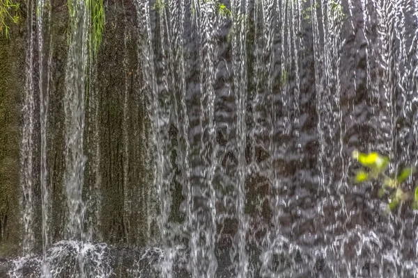 Vista detalhada de uma pequena cascata no rio, colorido e textura de água caindo — Fotografia de Stock