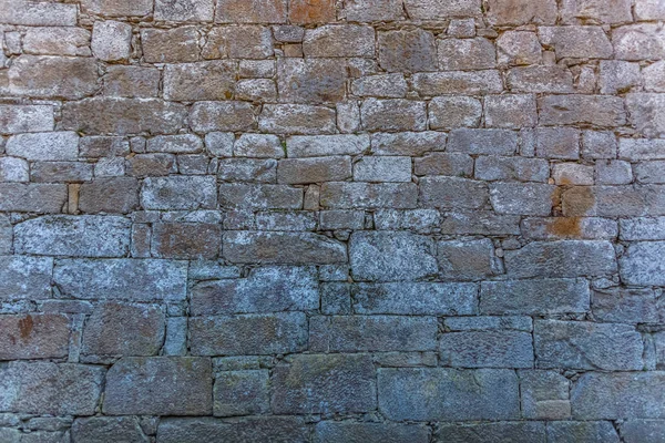 Vista del patrón con textura de pared exterior del edificio antiguo hecho en piedra granítica emparejada —  Fotos de Stock