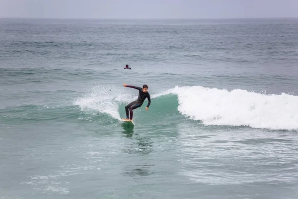 Strandutsikt med professionella surfare gör extrema manövrar i havet med vågor — Stockfoto