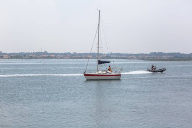 Aveiro nehri manzarası ile özel eğlence tekneleri yelken. Tipik bitki örtüsü ve binalar ile bulutlar ve arka plan ile Gün