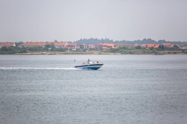 Aveiro nehri manzarası ile özel eğlence tekne yelken. Tipik bitki örtüsü ve binalar ile bulutlar ve arka plan ile Gün