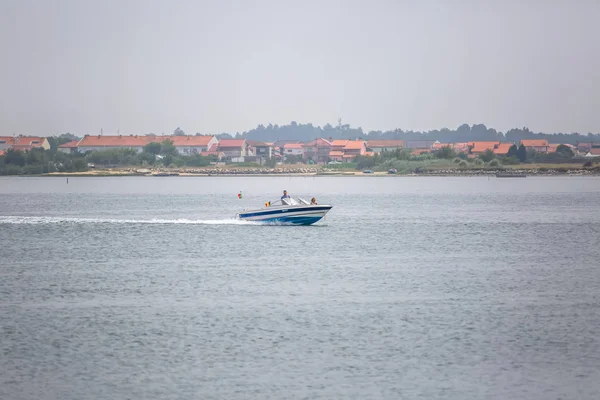 Vista del río Aveiro con barco recreativo privado con gente navegando. Día con nubes y fondo con vegetación y edificios típicos — Foto de Stock