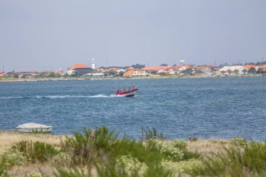 Aveiro nehri manzarası ile özel eğlence tekne yelken. Tipik bitki örtüsü ve binalar ile bulutlar ve arka plan ile Gün