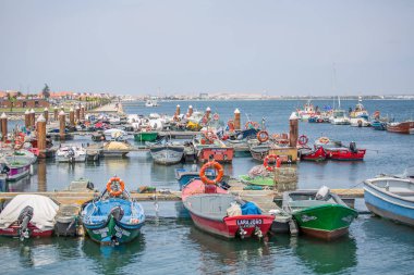 Özel eğlence tekneleri ve balıkçı tekneleri ile Aveiro nehir ve marina manzarası. Bulutlar ve arka plan ile Gün