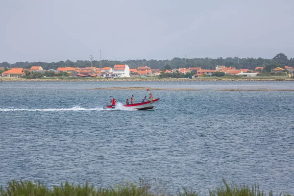 Aveiro nehri manzarası ile özel eğlence tekne yelken. Tipik bitki örtüsü ve binalar ile bulutlar ve arka plan ile Gün