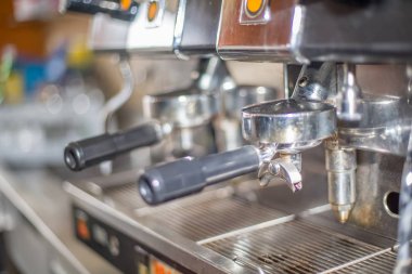 Detailed view of a professional Italian espresso machine with detail of ground coffee handles