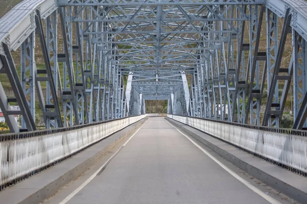 Perspektiv mittvinkel vy vid bron i metallic truss struktur över Dourofloden i Pinhao stad, asfalterad väg — Stockfoto