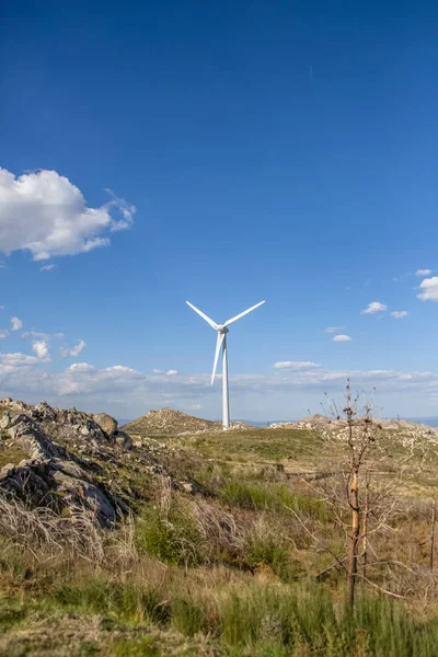 Uitzicht op een windturbine op de top van bergen, blauwe lucht als achtergrond — Stockfoto