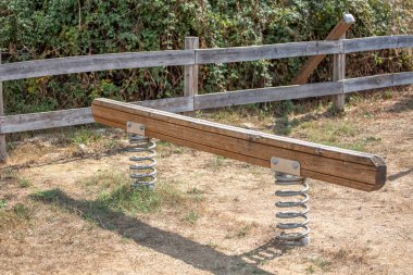 Modern ahşap salıncak, metal yaylar, açık hava çocuk parkındaki ekipmanlar....