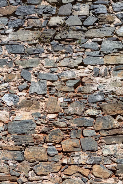 View of a rustic and old schist exterior wall, architectural textures, detailed wall masonry schist...