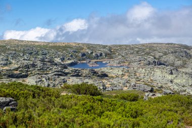 Serra da Estrela doğal parkı, Star Mountain Sıradağları, küçük göl, kayalar ve bitki örtüsü ve dağ manzarası....