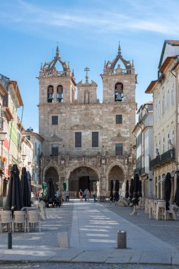 Braga / Portekiz 09: 12 2020: Braga Katedrali 'nin ana cephesi. Üç gotik kemerli giriş galerisi, 15. yüzyıl, kuleler ve üst katlar, erken barok, ön meydanlar ve turistler.