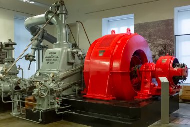 Seia / Portugal - 08 22 22 2020: 1934 model endüstriyel hidroelektrik jeneratör türbini ve motorun elektrik müzesindeki sergi salonunda görüntülenmesi