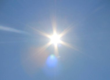 Mavi gökyüzünde parlayan güneş.