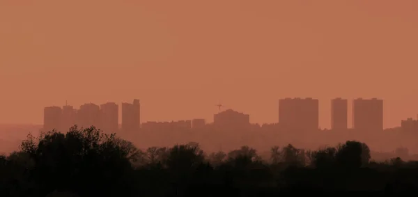 Urban landscape at sunset with silhouette of houses