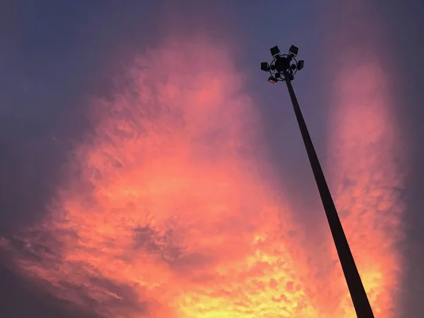 Beautiful purple sky with scattered of clouds and light pole silhouette.