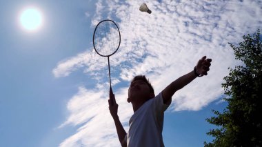 Asyalı çocuk onun badminton pratik hizmet sıcak güneşli bir günde. (seçili odaklama)