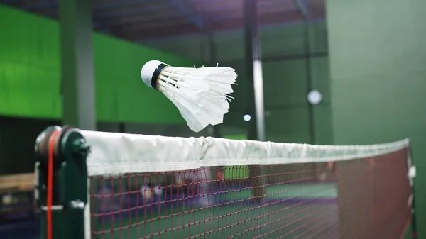 Fechar de badminton Shuttlecock voando através da rede . — Fotografia de Stock