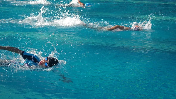 Asiatischer Junge schwimmt im Wettkampf mit warmem Sonnenlicht von th — Stockfoto